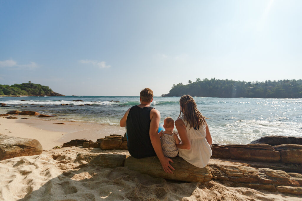 Back,View,Of,Family,With,Little,Child,Sitting,On,Tropical